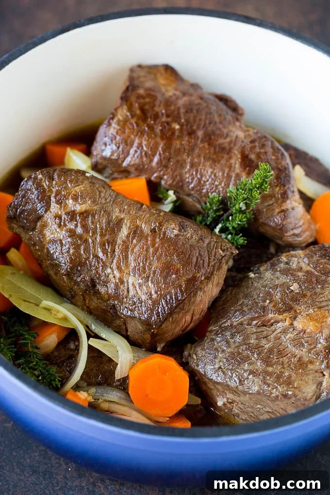 Delicious Braised Short Ribs with Vegetables Braised short ribs with tender carrots and onions simmering in a rich sauce.
