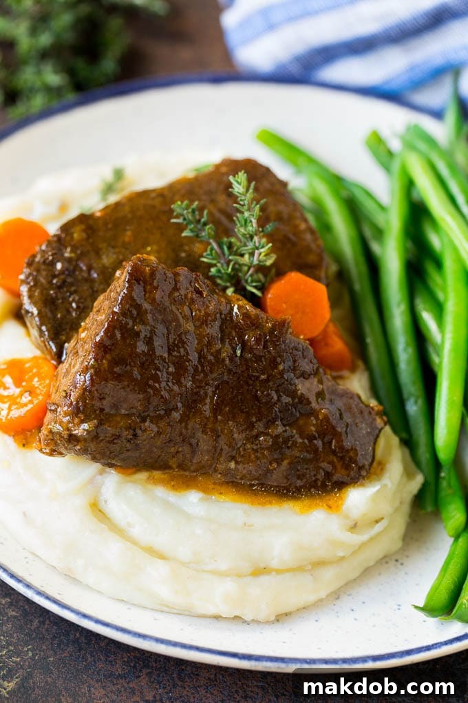 Serving Braised Short Ribs with Mashed Potatoes Plated braised short ribs over mashed potatoes with a side of green beans, drizzled with rich sauce.