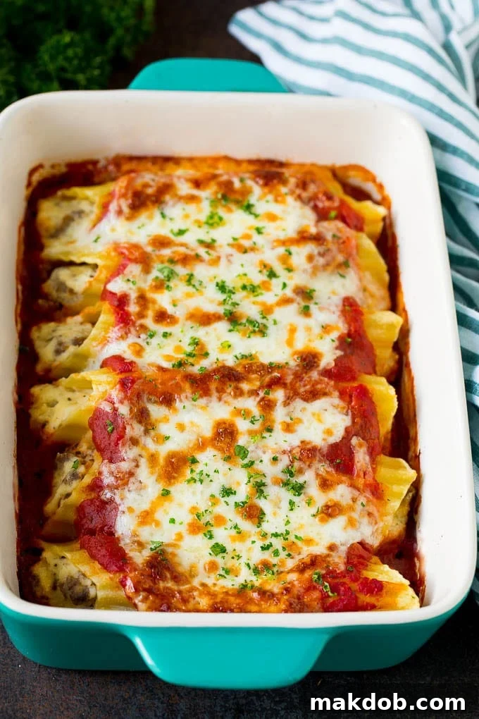 A dish of baked manicotti pasta topped with melted cheese and parsley, ready to be served.