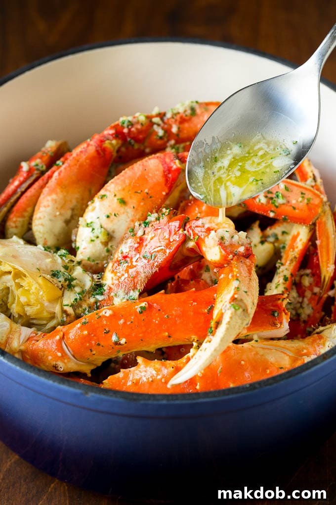 A spoon pouring garlic butter over cooked crab.