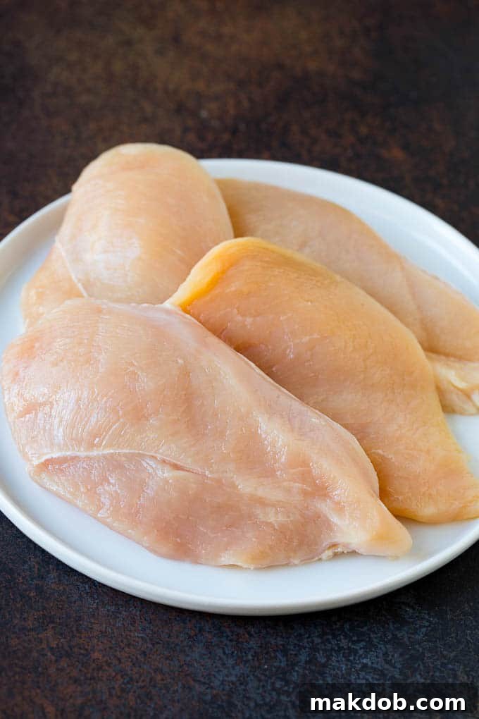 Chicken Scallopini Recipe #chicken #chickenbreast #dinner #dinneratthezoo Thinly sliced chicken breasts on a plate.