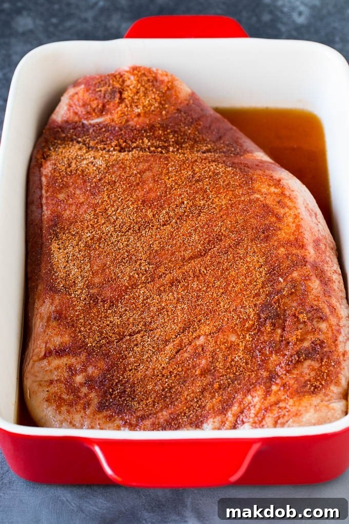 A beef brisket generously coated in a homemade spice rub, ready for slow cooking to absorb deep flavors.