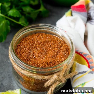 A jar of taco seasoning with a savory blend of spices.
