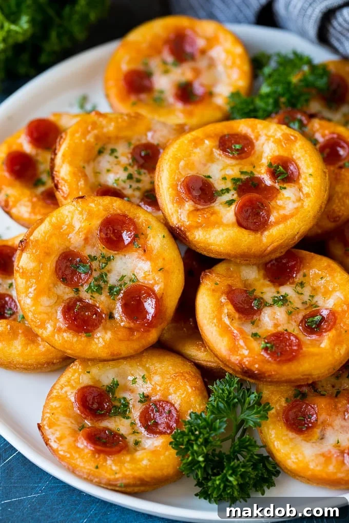 Mini pizzas topped with pepperoni are a fun and easy appetizer option. #pizza #dinneratthezoo #appetizer Mini pizzas topped with melted cheese and pepperoni.