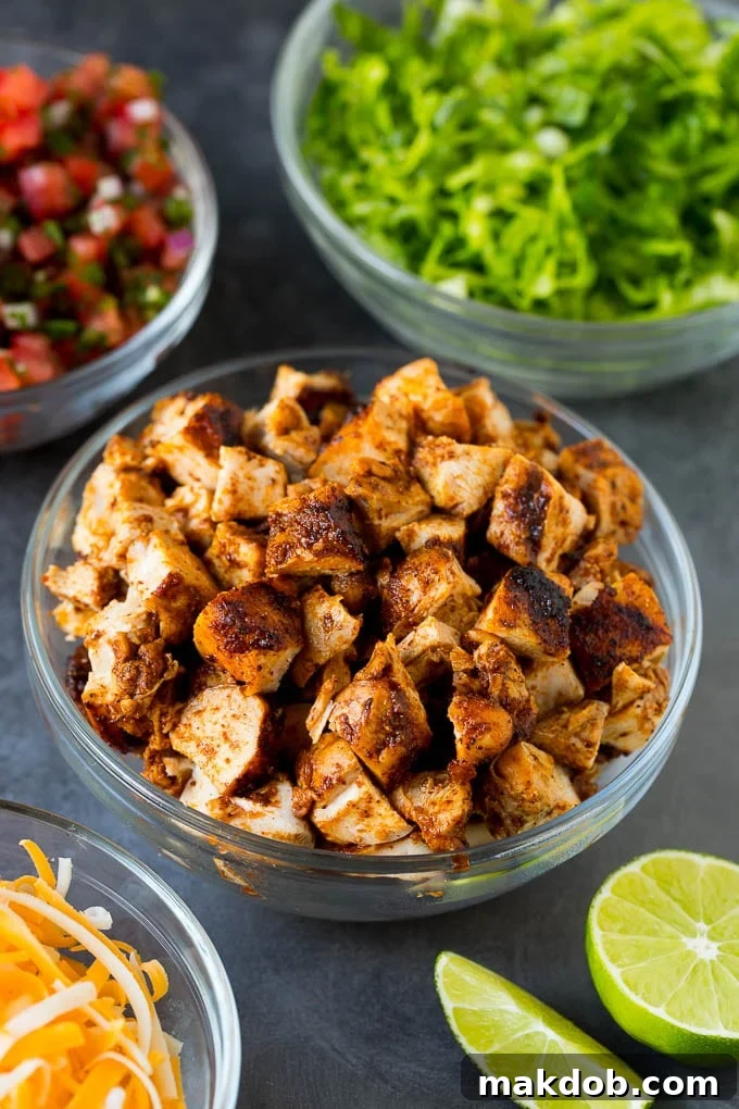 Diced chicken, shredded lettuce, salsa and cheese in bowls.