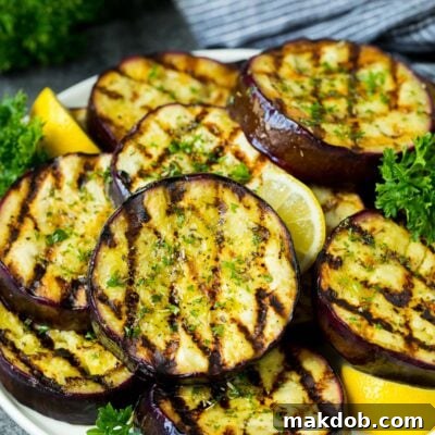 Fire-Kissed Eggplant 7 A platter of grilled eggplant garnished with lemon and parsley.