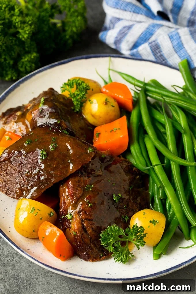 Slow cooker pot roast served with carrots, potatoes and green beans.