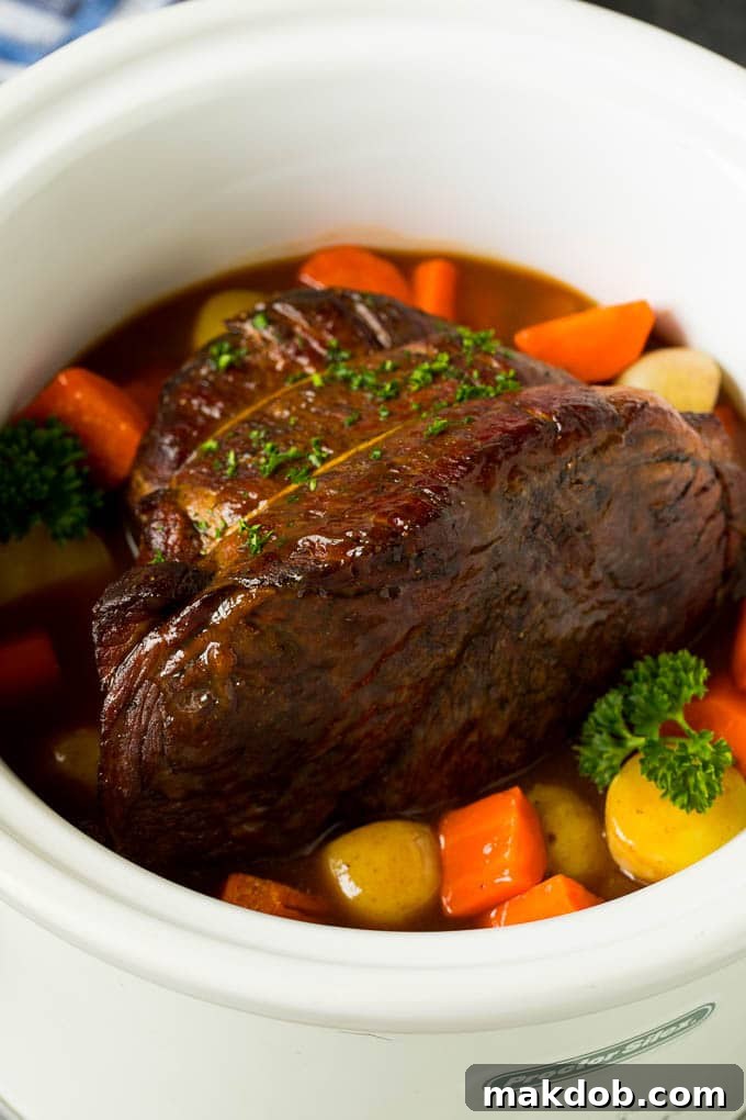 Slow cooker pot roast with carrots, potatoes and gravy.