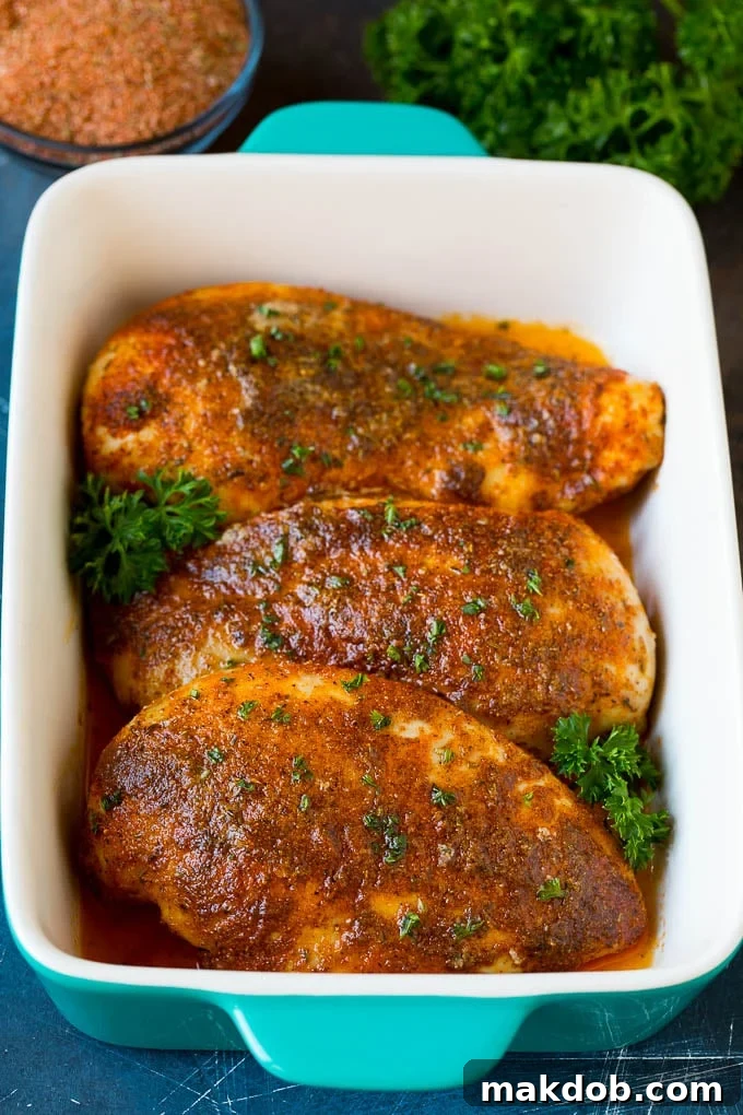 Homemade Cajun seasoning made with a unique blend of herbs and spices. #cajun #dinneratthezoo Cooked chicken breasts topped with vibrant Cajun seasoning and fresh herbs, ready to be served.