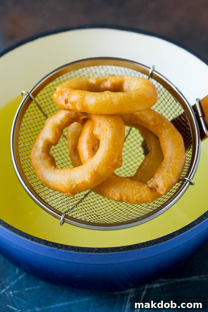 Fried onions coming out of a pot of oil.