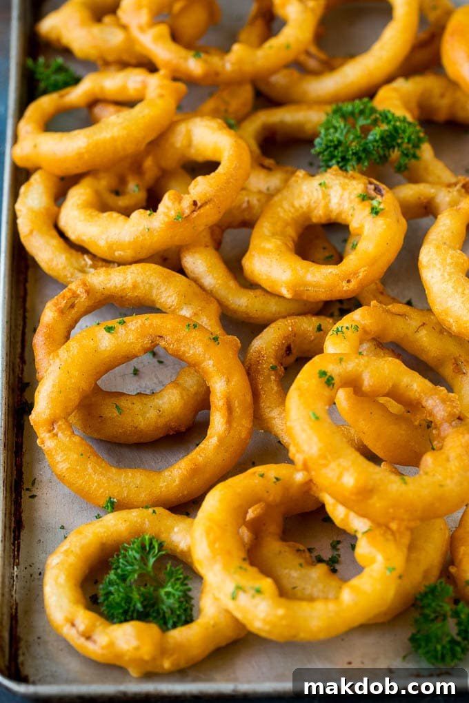 Beer battered onion rings on a sheet pan.