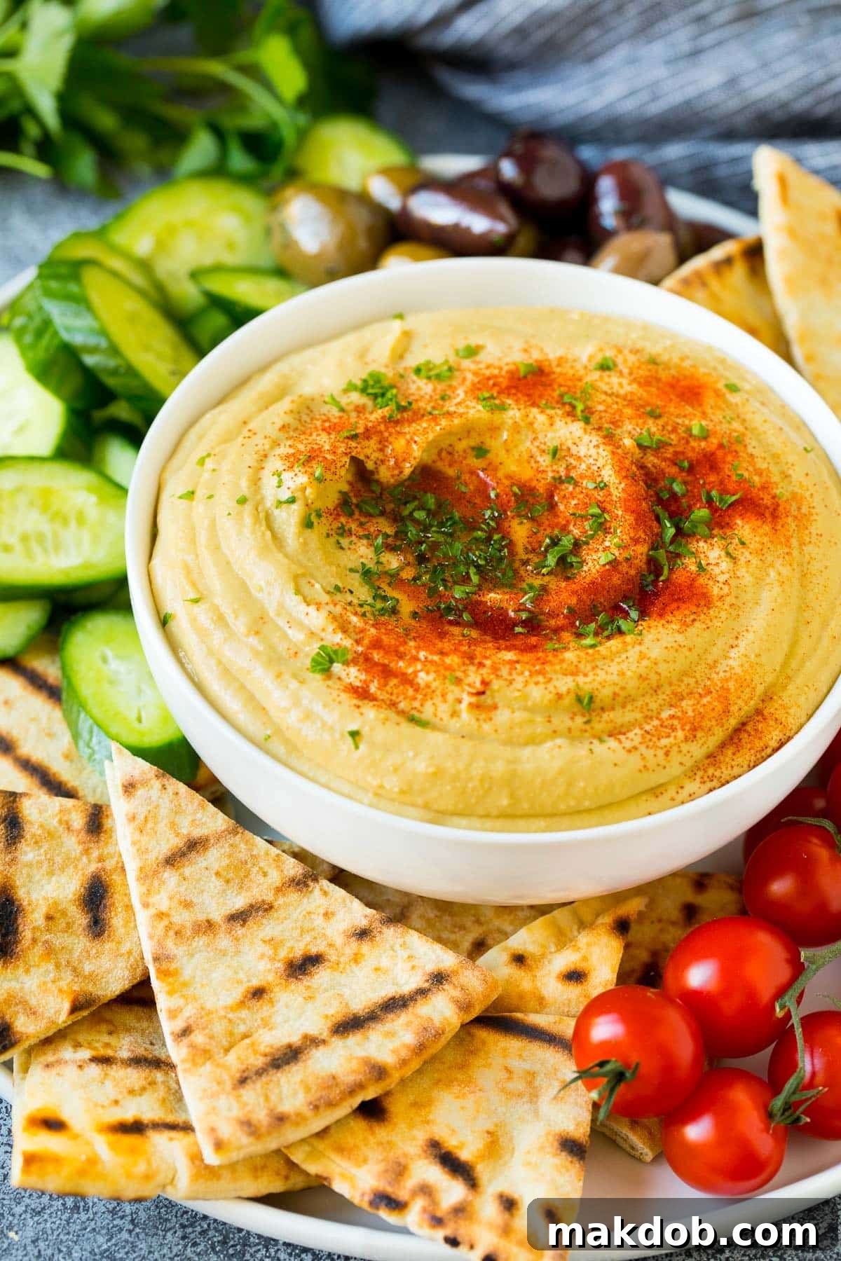 A bowl of homemade hummus served with pita and vegetables. Perfect for a healthy appetizer or snack.