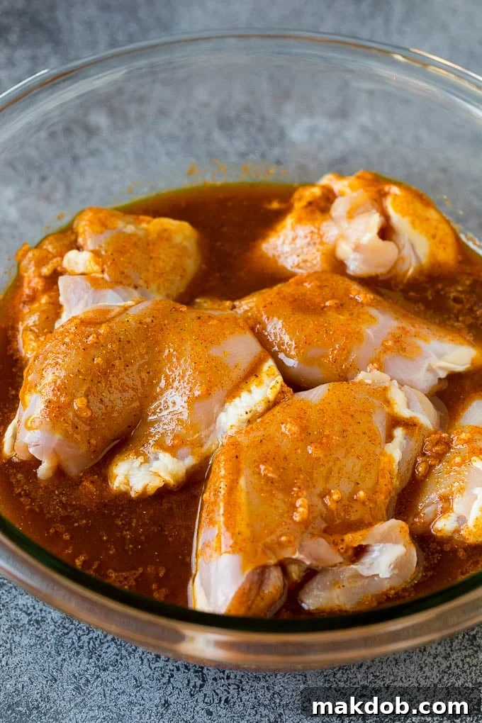Chicken thighs in a bowl of marinade.