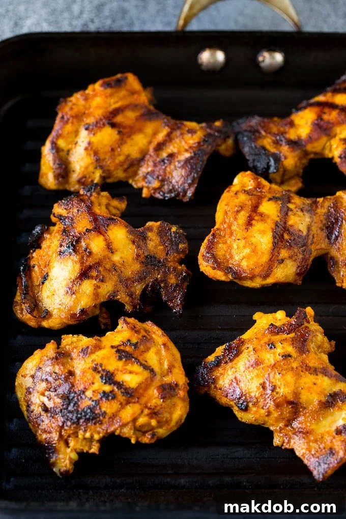 Cooked chicken thighs on a grill pan.