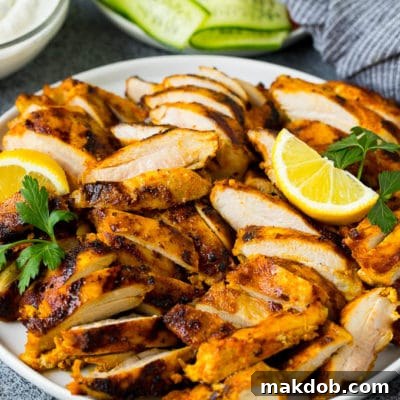 Sliced chicken shawarma garnished with parsley and lemon.
