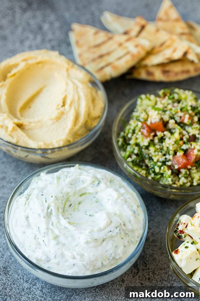 An Odyssey of Mediterranean Flavors 3 Bowls of hummus, tzatziki and tabbouleh.