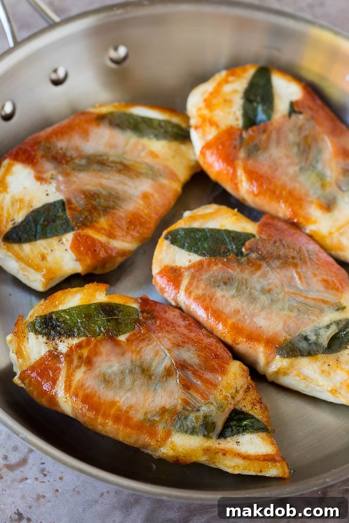 Pan-seared chicken breasts wrapped in crispy prosciutto, swimming in a rich sauce.