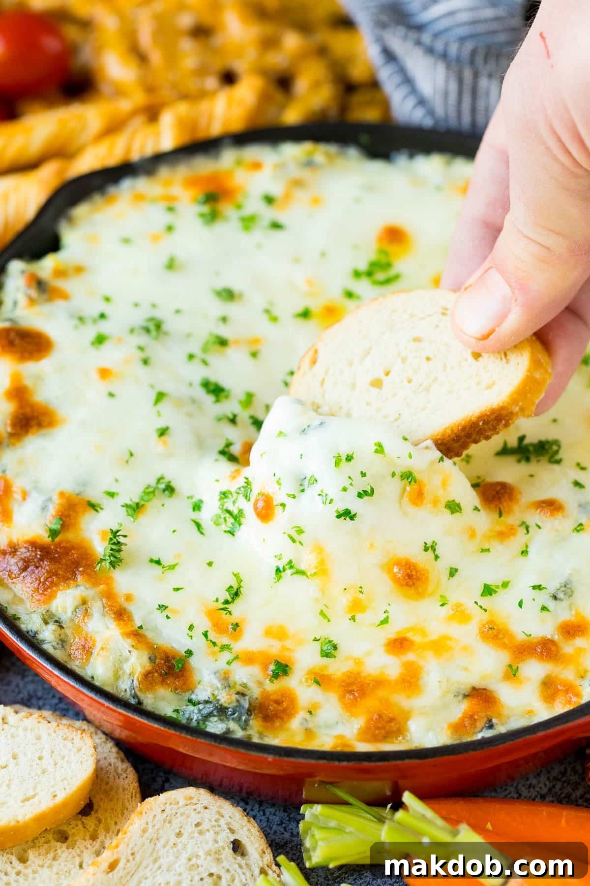 Bread in a pan of cheesy dip.