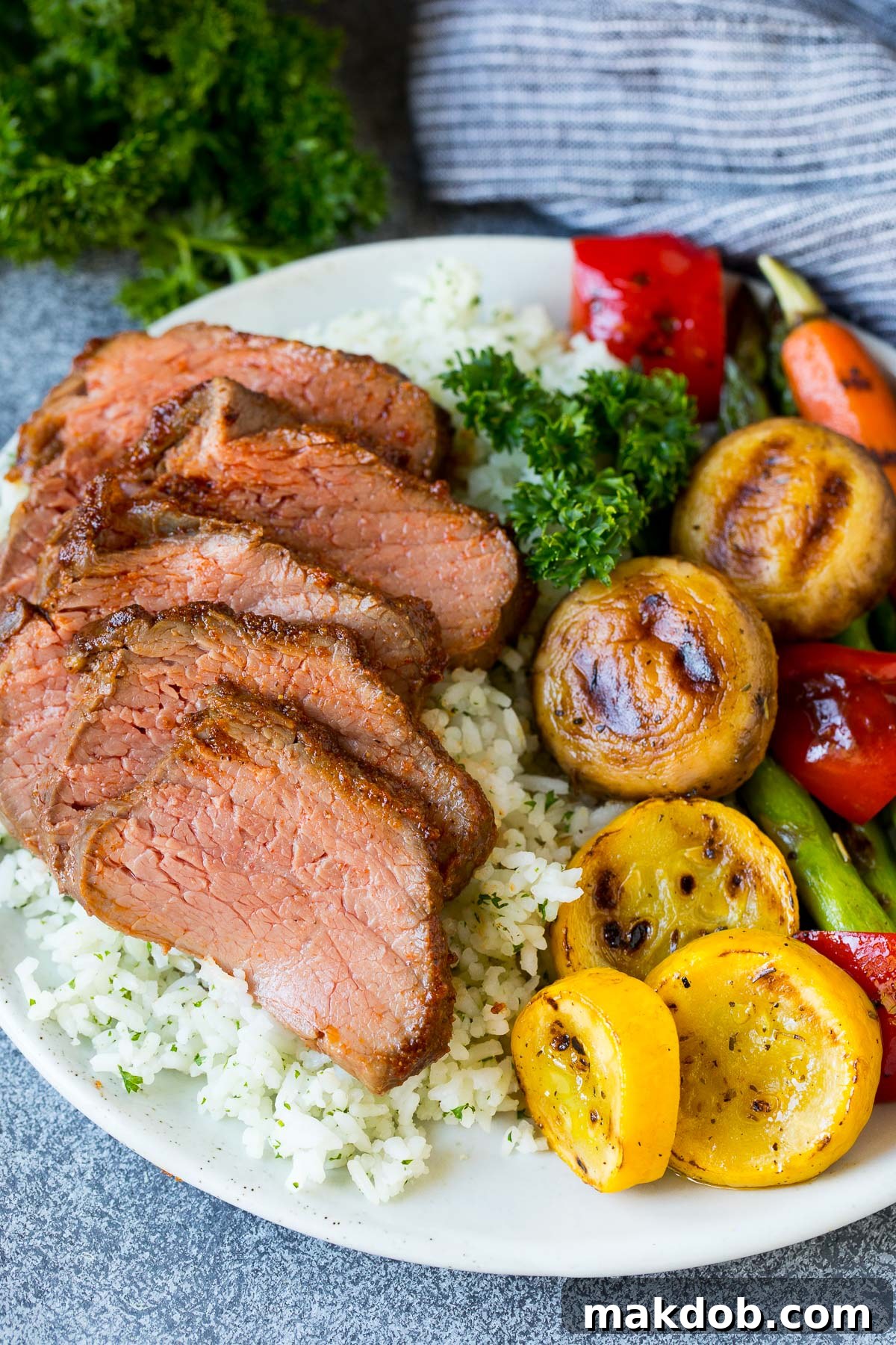 Smoky Tri Tip Perfection 6 A plate of perfectly sliced smoked tri tip with rice and fresh vegetables.