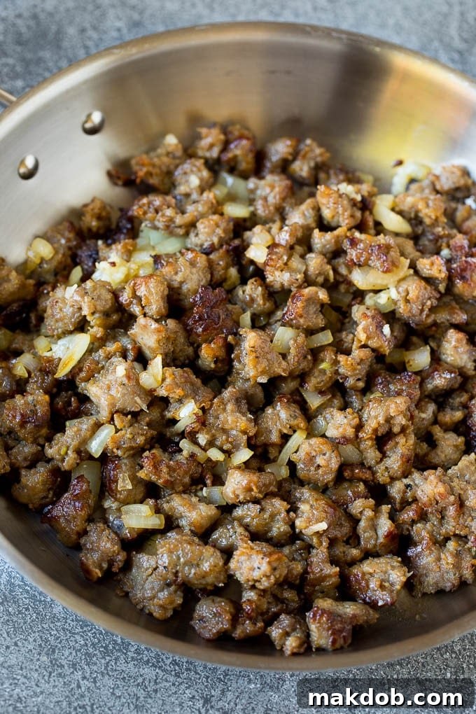 Sausage and Onions for Pasta al Forno Sauce Browned Italian sausage and onions sizzling in a pan, the base for a rich pasta sauce.
