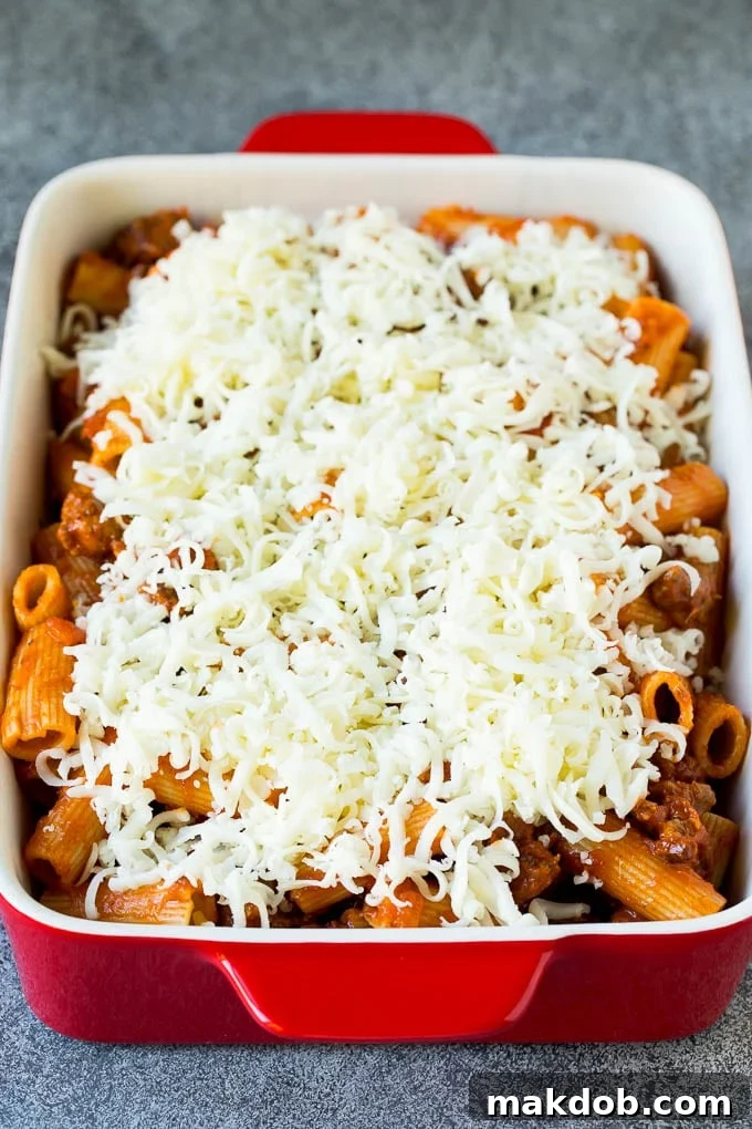 Pasta al Forno Ready for the Oven A dish of rigatoni tossed in meat sauce and topped with shredded mozzarella cheese, ready for baking.