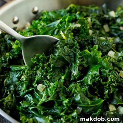 A pan of sauteed kale with a serving spoon in it.