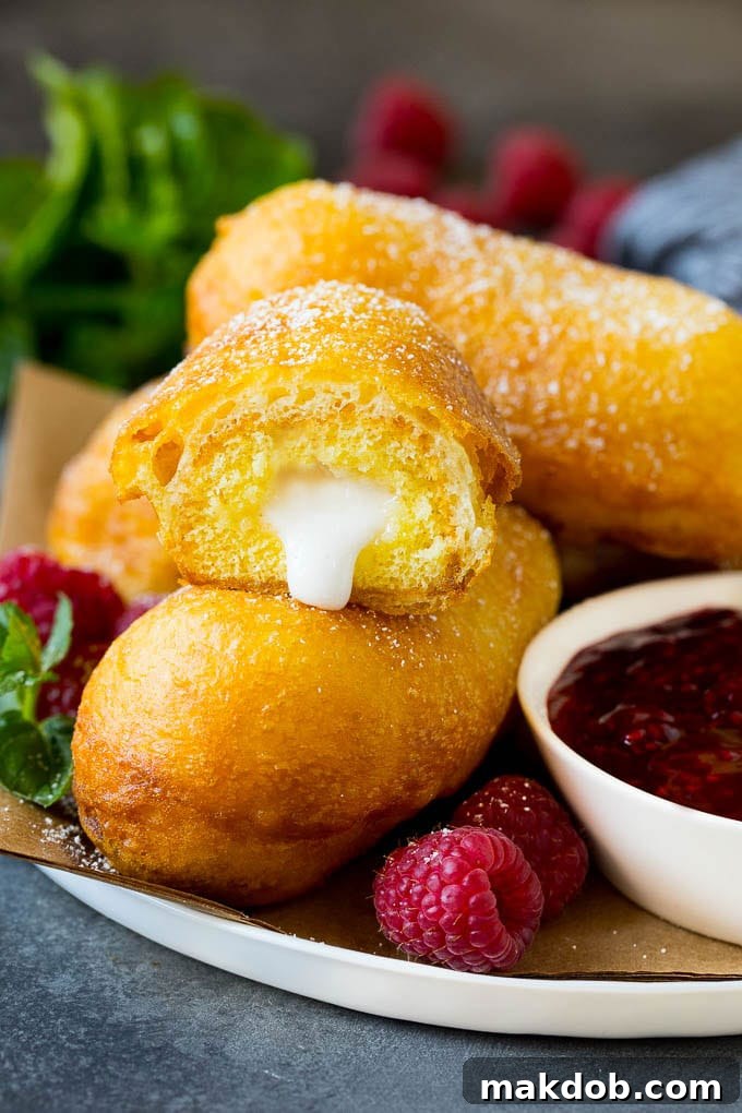 Fried Twinkies are a remake of the carnival classic that are fun and easy to make at home. A plate of fried Twinkies served with raspberry sauce.
