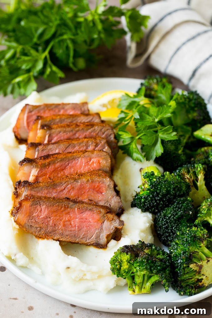Perfectly cooked steaks coated with seasoning, sliced and served over creamy mashed potatoes.