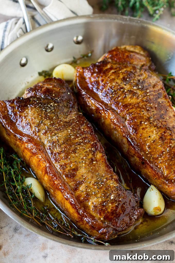 Seared New York strip steak with garlic and herb butter, an easy and elegant meal! Seared New York strip steak served in garlic butter.