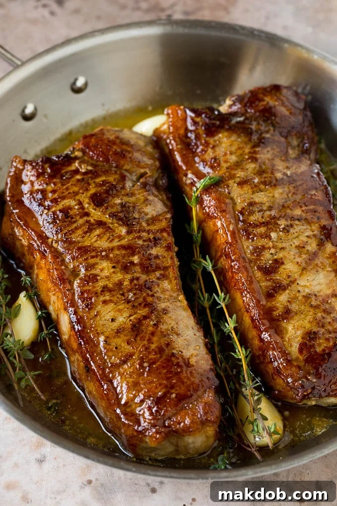Seared New York strip steak with garlic and herb butter, an easy and elegant meal! Strip steaks with butter, garlic and herbs.