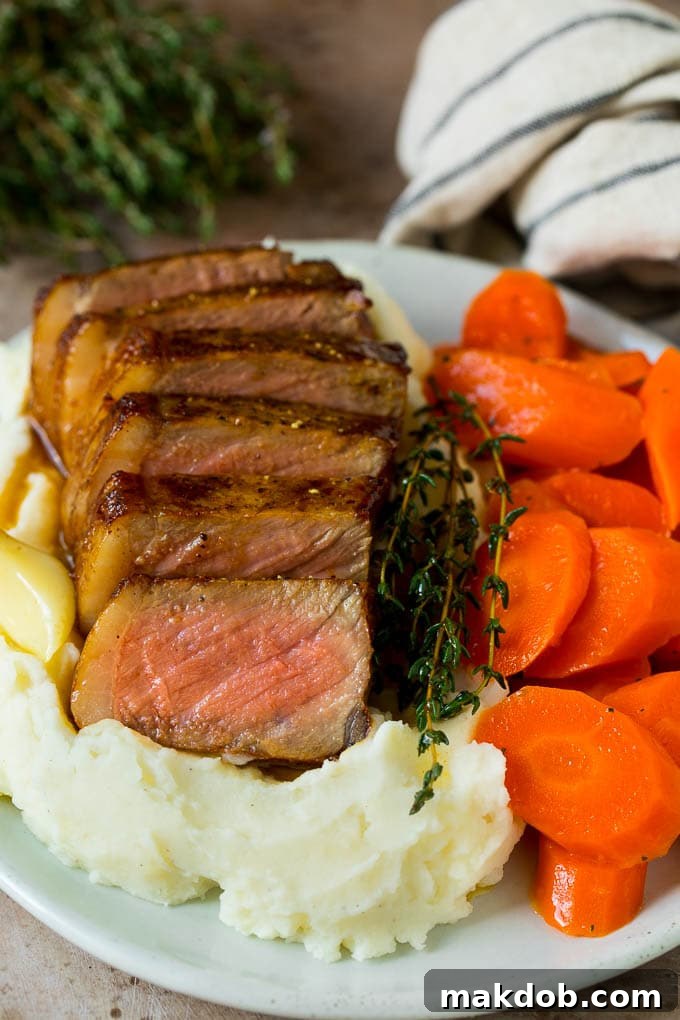 Sliced New York strip steak served with mashed potatoes and carrots. Sliced New York strip steak served with mashed potatoes and carrots.