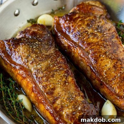 Seared New York strip steak served in garlic butter.