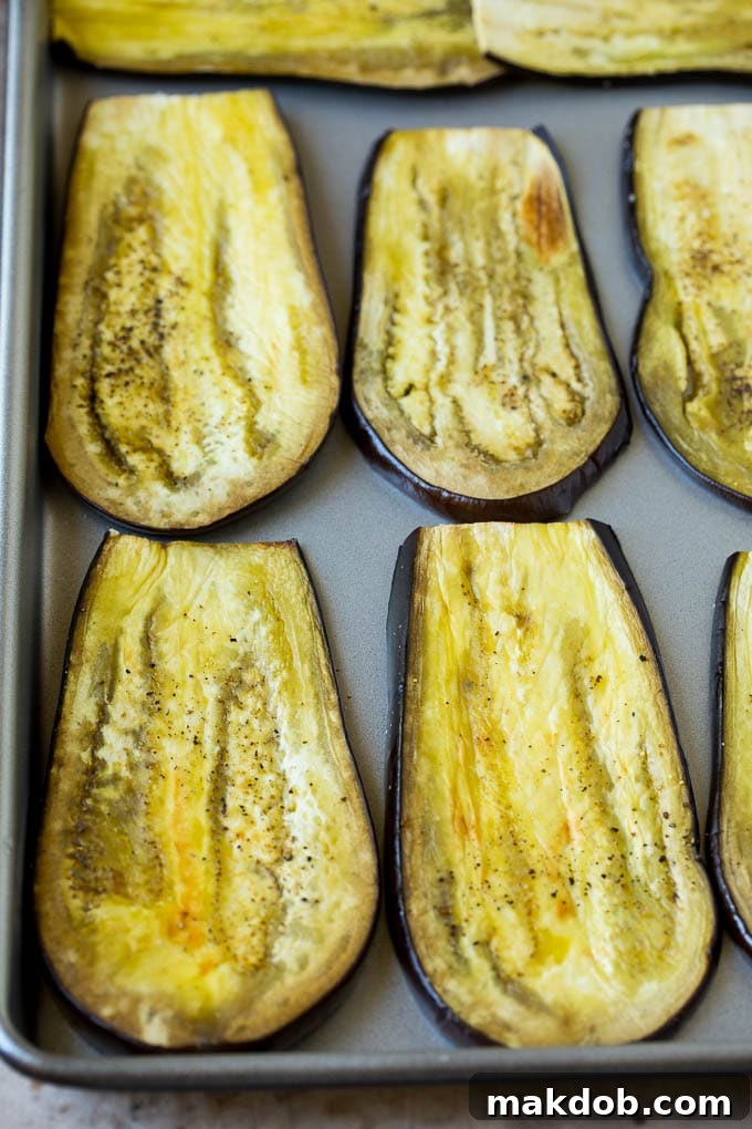 Roasted eggplant slices laid out on a sheet pan, ready for assembly.