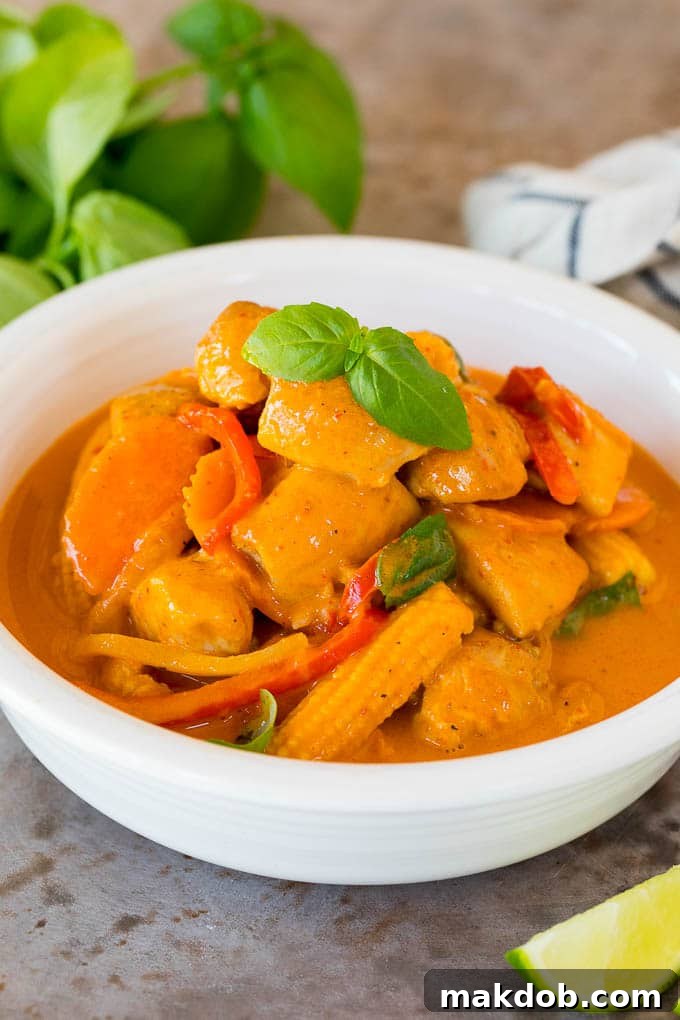 This Thai chicken curry is pieces of tender chicken and colorful vegetables, all simmered together in a coconut red curry sauce. A bowl of Thai chicken curry topped with fresh basil.