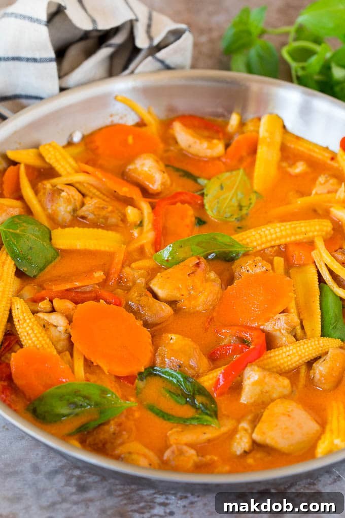 This Thai chicken curry is pieces of tender chicken and colorful vegetables, all simmered together in a coconut red curry sauce. A pan of Thai chicken curry in a creamy red sauce with vegetables.
