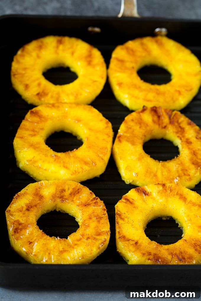 Perfectly cooked pineapple slices arranged on a grill pan, showing lovely char marks.