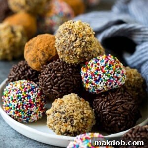 Luxurious chocolate truffles, beautifully coated in a variety of toppings like nuts, sprinkles, and rich cocoa powder.