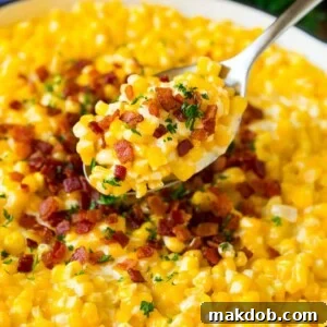 A generous spoonful of creamy creamed corn, elegantly topped with crispy bacon bits and fresh herbs.