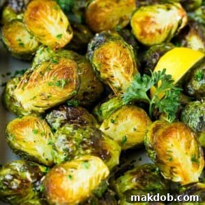 Perfectly crispy Brussels sprouts, artfully garnished with bright lemon slices and fresh parsley.