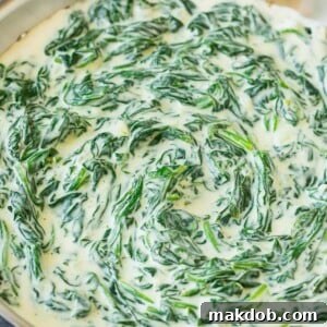 A steaming pan of rich and creamy creamed spinach, ready to be served.