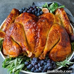 A perfectly cooked spatchcock turkey, elegantly garnished with sweet grapes and fresh herbs, ready for serving.