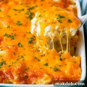 A spoon serving a hearty portion of cheesy potatoes, elegantly topped with freshly chopped parsley.
