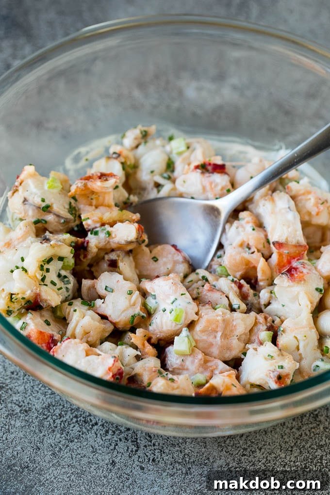 Lobster Salad Fully Mixed in a Bowl A large mixing bowl containing a generous amount of lobster meat fully tossed and coated in a creamy, vibrant dressing, perfectly combined.