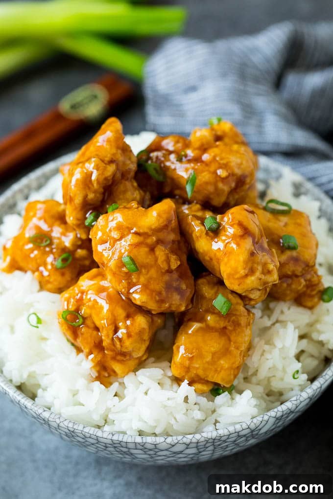 Honey Chicken with Steamed Rice Honey chicken served over a bowl of steamed rice, garnished with green onions.