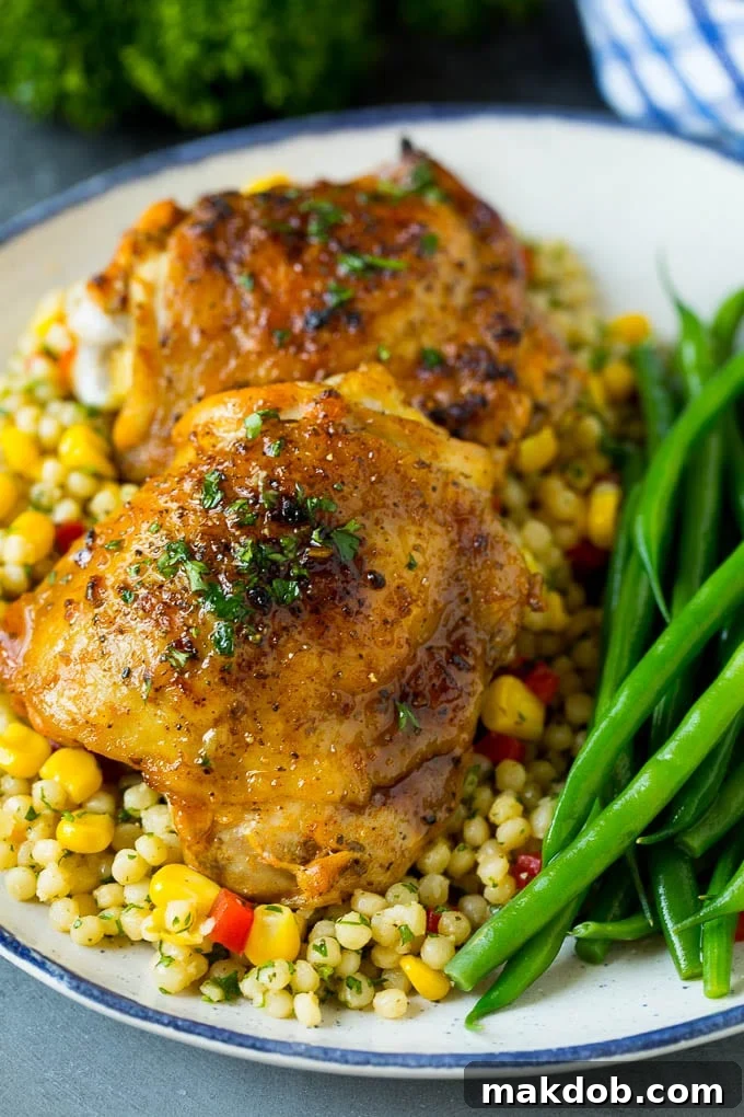 These baked chicken thighs are coated in olive oil, garlic and herbs, then oven roasted until golden brown. Baked chicken thighs served over couscous with a side of green beans.