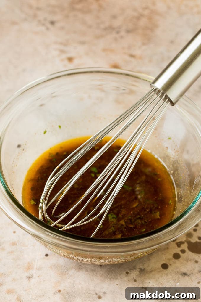 Homemade salad dressing in a bowl with a whisk.