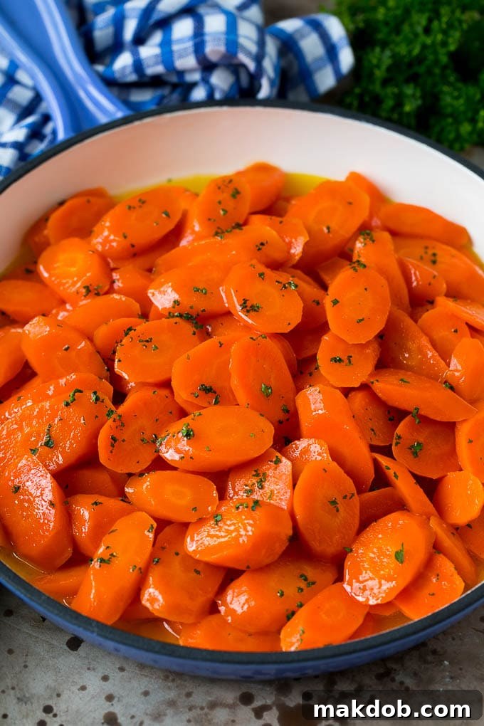 Honey glazed carrots in a blue pan, topped with parsley.