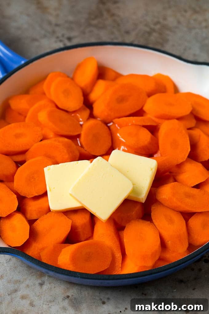 Cooked carrots, butter and honey in a pan.