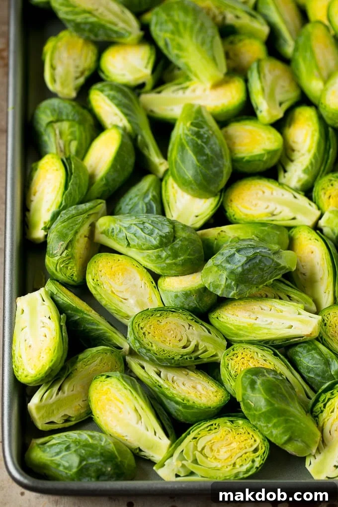 Halved Brussels sprouts on a baking sheet, ready for roasting.