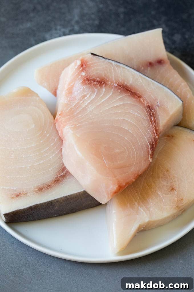 Raw fish fillets on a plate, ready for marinating.